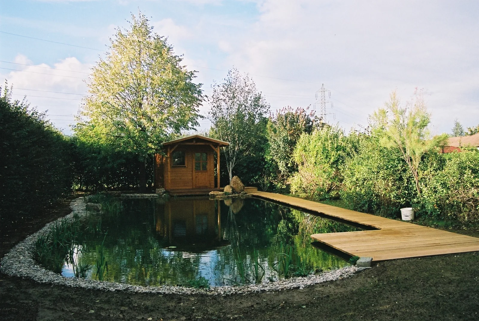 Schwimmteich mit Holzsteg und Gartenhaus